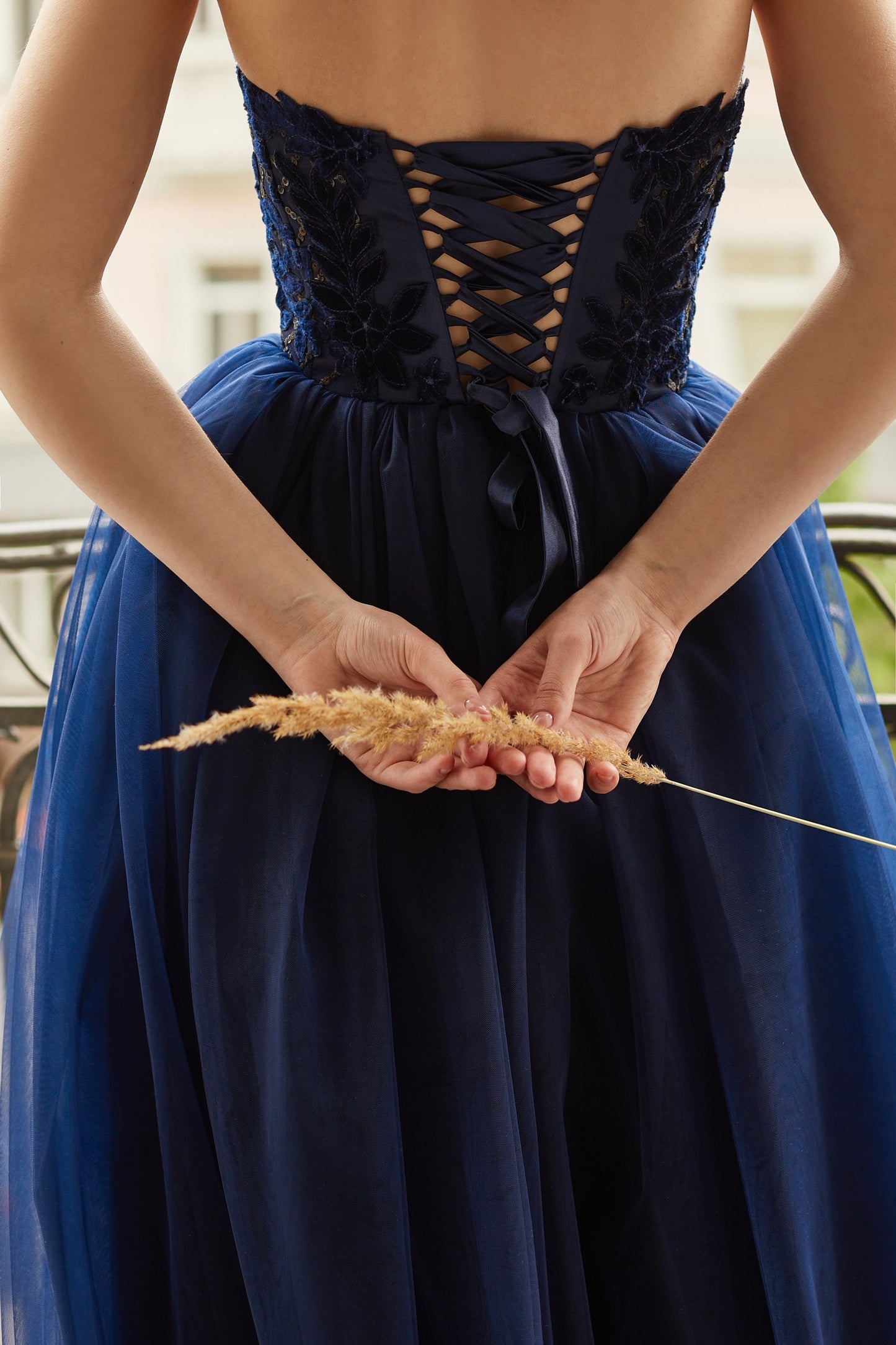 Navy blue evening gown with tulle skirt and side split, V-shape corset embroidered with velvet flowers and sequins.