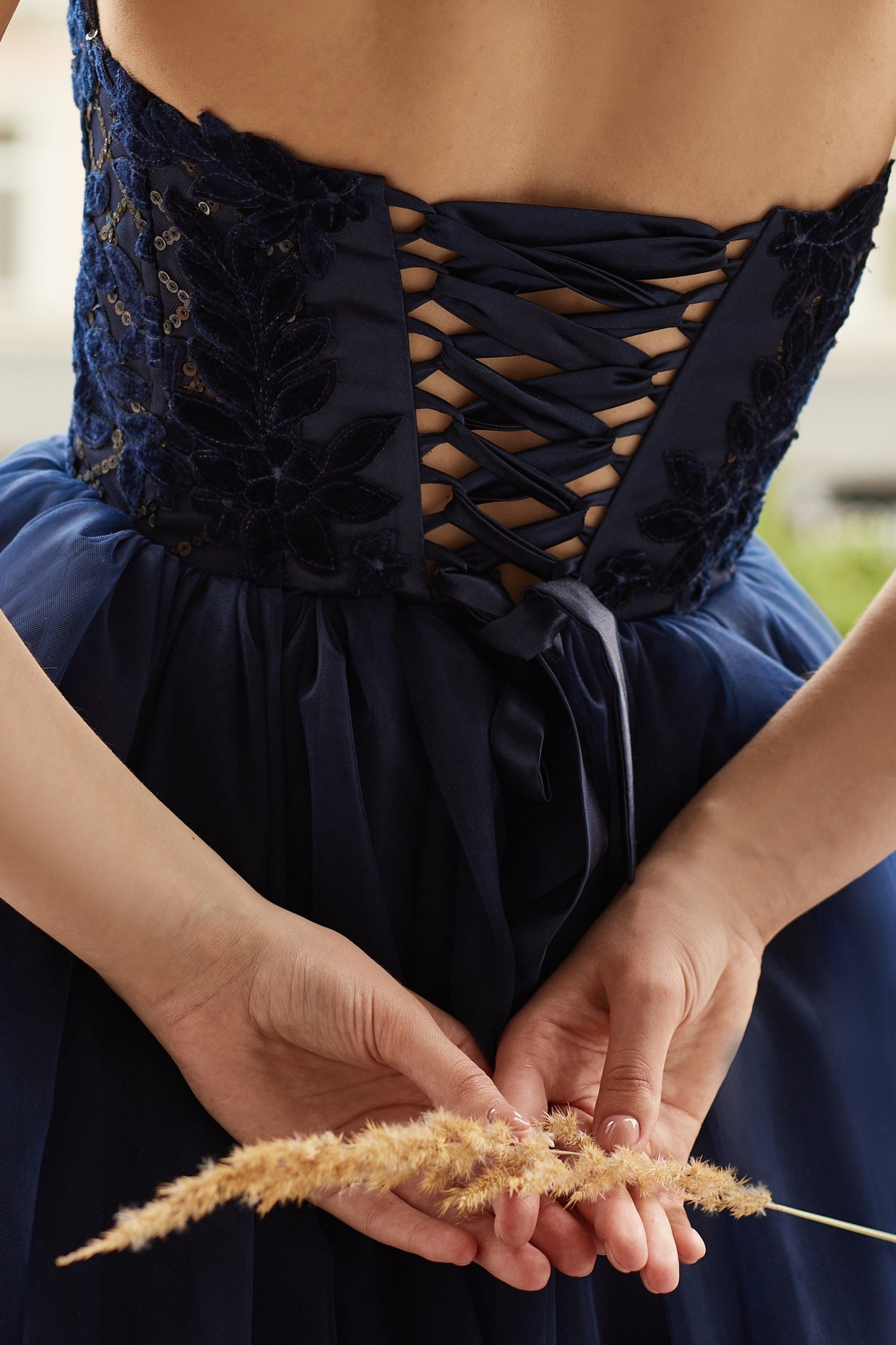 Navy blue evening gown with tulle skirt and side split, V-shape corset embroidered with velvet flowers and sequins.