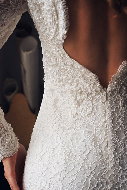 Open back of this mermaid gown is heavy embroidered with pearls an sequins.