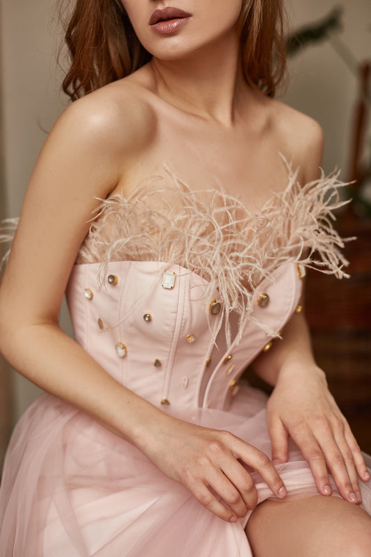 Blush pink dress decorated with feathers and rhinestones. Bodice is V-shape corset, fit and flare skirt, covered with tulle.
Perfect as a prom dress, alternative bride, wedding guest dress or evening gown.
