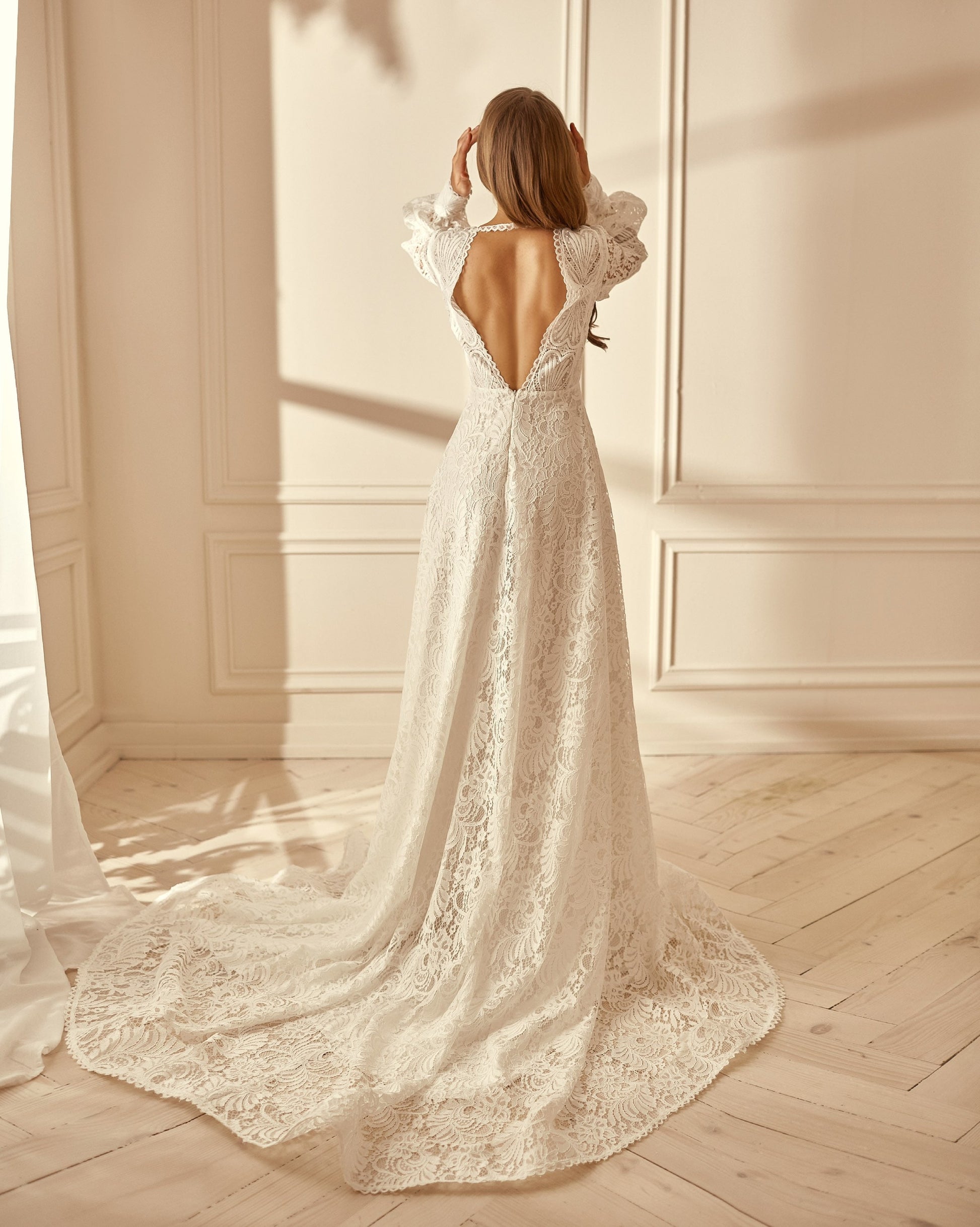Open back wedding dress with dramatic train made from thick white lace
