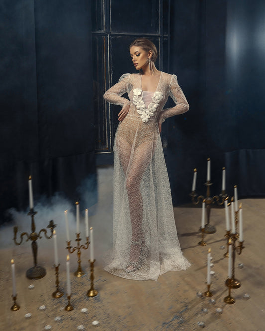 Bohemian wedding dress made from lace and embroidered with ribbon flowers. Volumetric sleeves, fit and flare skirt, sheer white fabric.